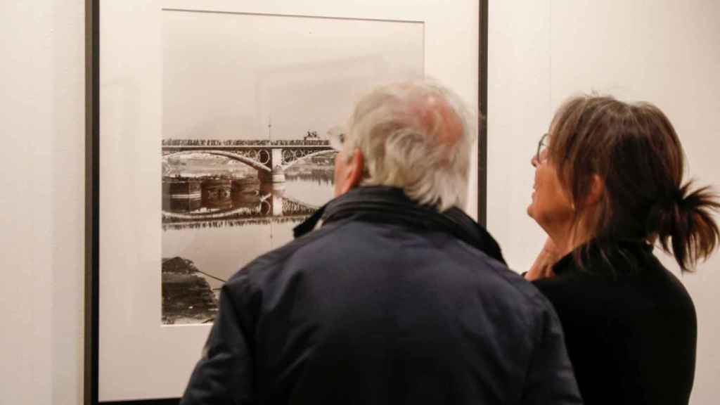 Dos visitantes leen una fotografía en Rastres Compartits