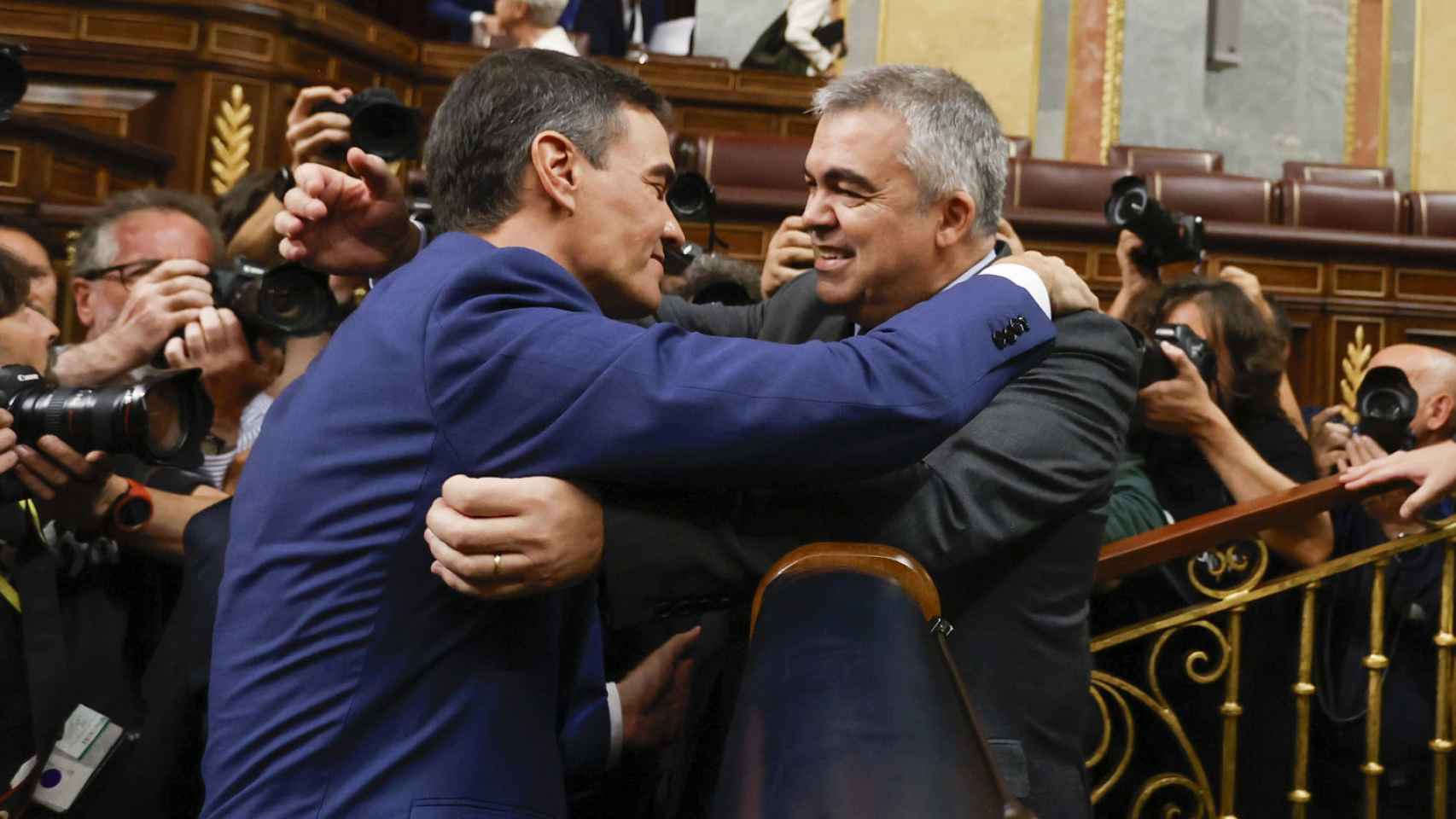 El líder del PSOE, Pedro Sánchez, abrazando a uno de los negociadores de su partido con Junts, Santos Cerdán, tras ser investido presidente del Gobierno