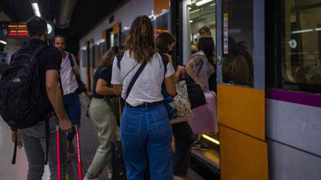 Viajeros suben a un tren en uno de los andenes de la estación de Sants