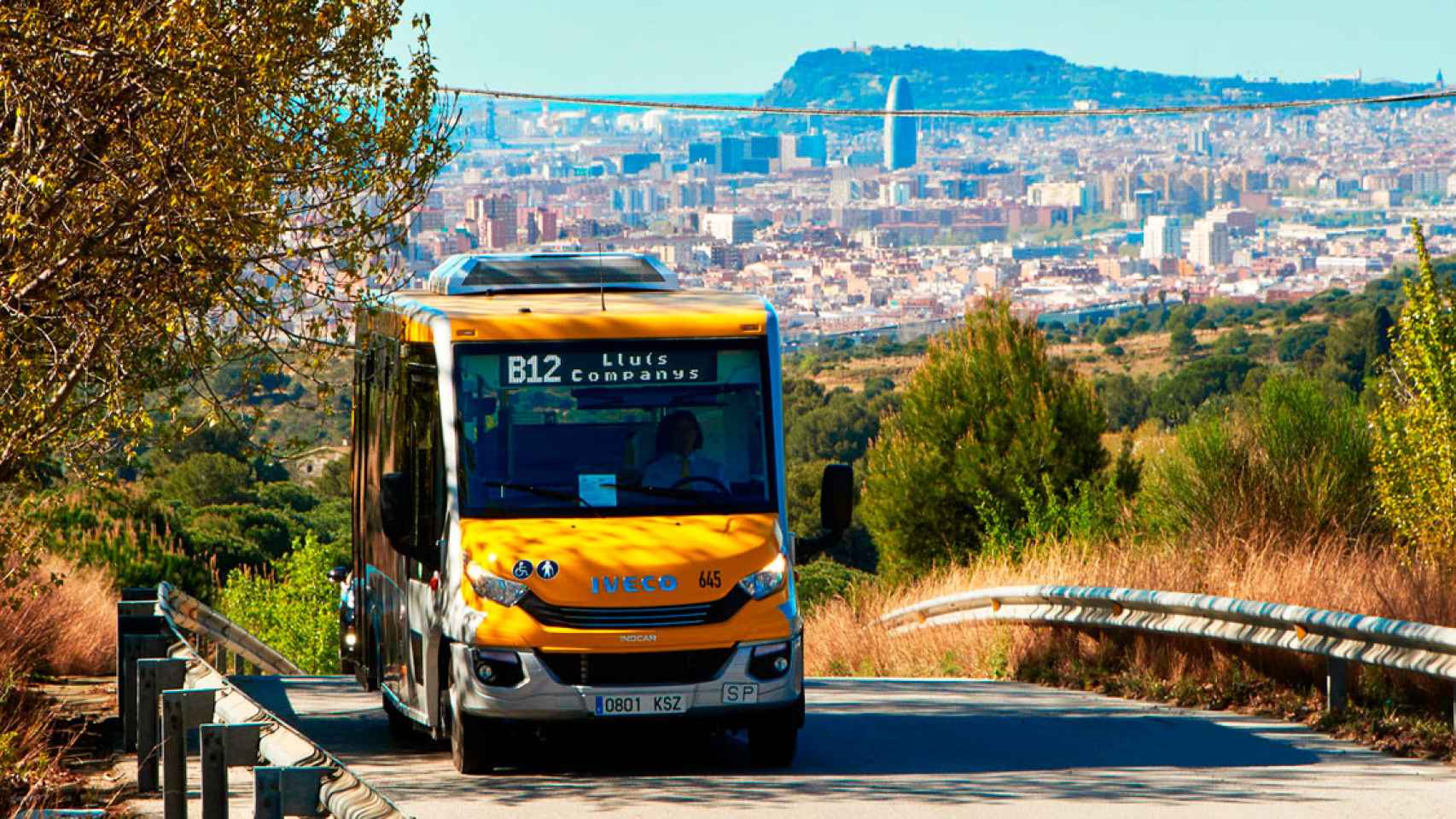 Un bus de Tusgsal con Barcelona de fondo