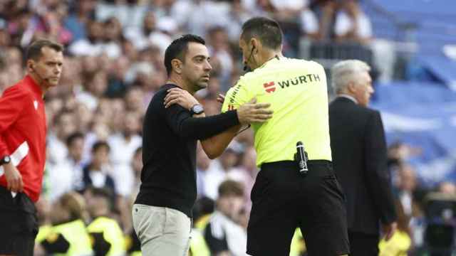Xavi conversa con Sánchez Martínez en un partido del Barça