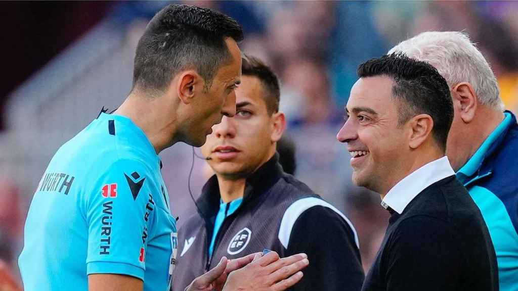 José María Sánchez Martínez dialoga con Xavi en un Barça-Atlético