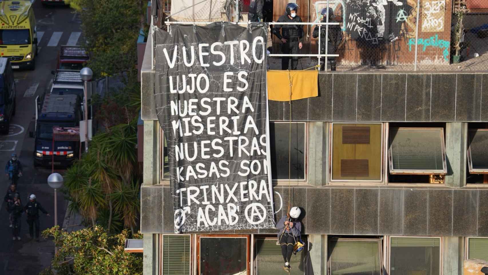 Los Mossos d'Esquadra intentan bajar a un okupa colgado de la fachada de El Kubo