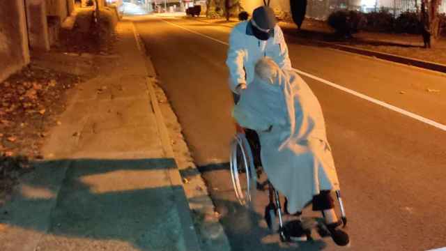 El marido de la señora mayor, empujando su silla de ruedas