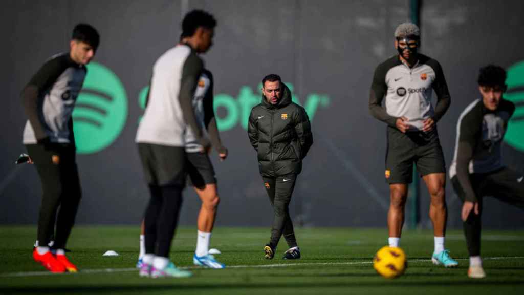 Xavi Hernández observa atentamente a los jugadores del Barça en un entrenamiento