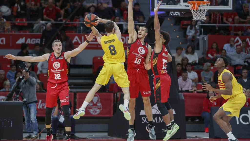 Darío Brizuela intenta asistir a James Nnaji en el Zaragoza-Barça de basket