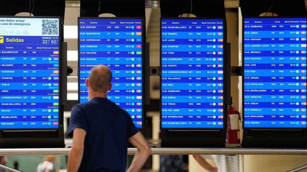 Un pasajero, ante las pantallas del Aeropuerto de El Prat