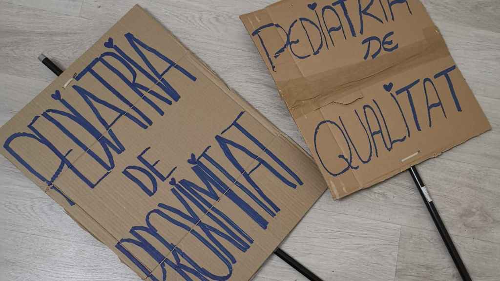 Unos vecinos preparan pancartas para manifestarse contra el nuevo modelo de concentración pediátrica