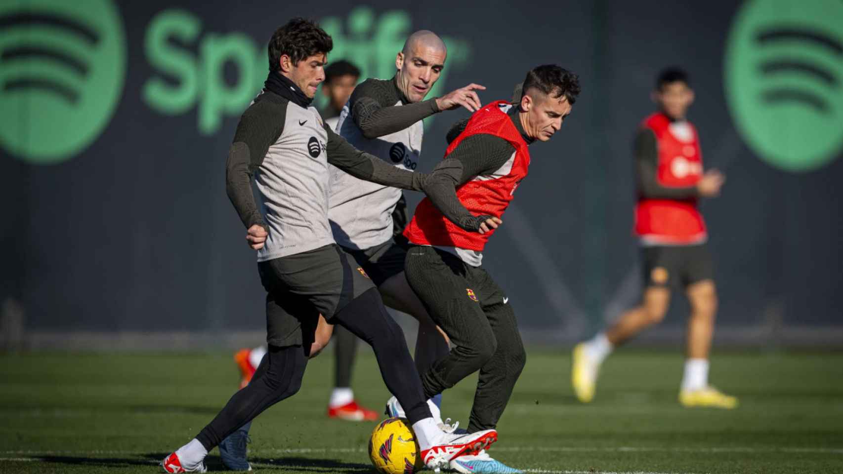 Oriol Romeu pugna por un balón con Sergi Roberto y Marc Casadó en un entrenamiento del Barça