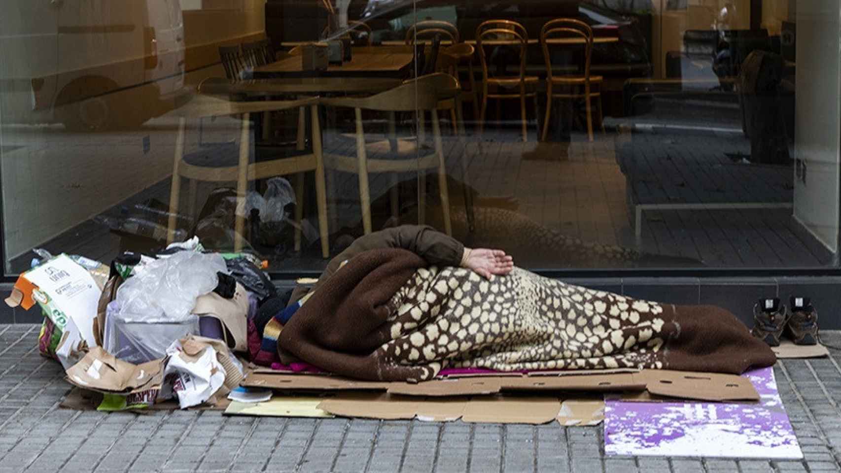 Una persona en situación de sinhogarismo durmiendo en la calle