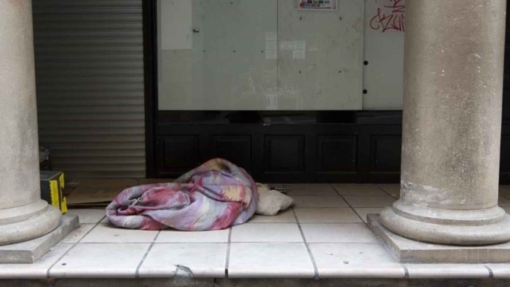 Una persona en situación de sinhogarismo durmiendo en la calle