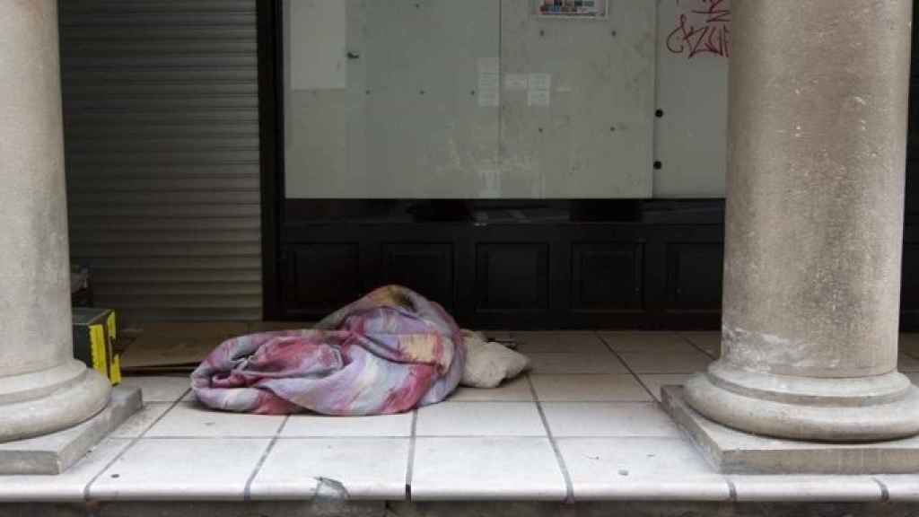 Una persona en situación de sinhogarismo durmiendo en la calle