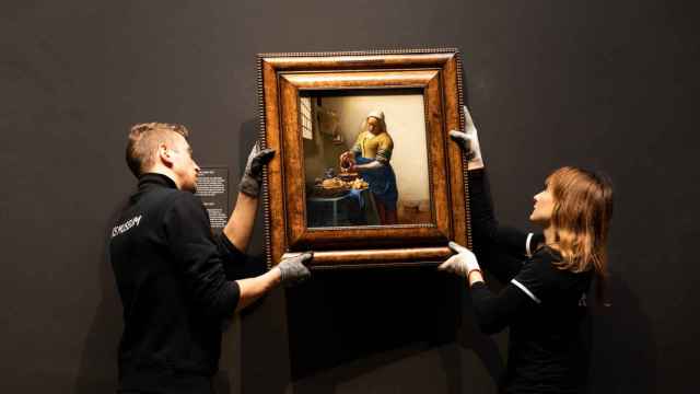 Dos operarios del Rijksmuseum colocan un cuadro de la exposición de Vermeer.