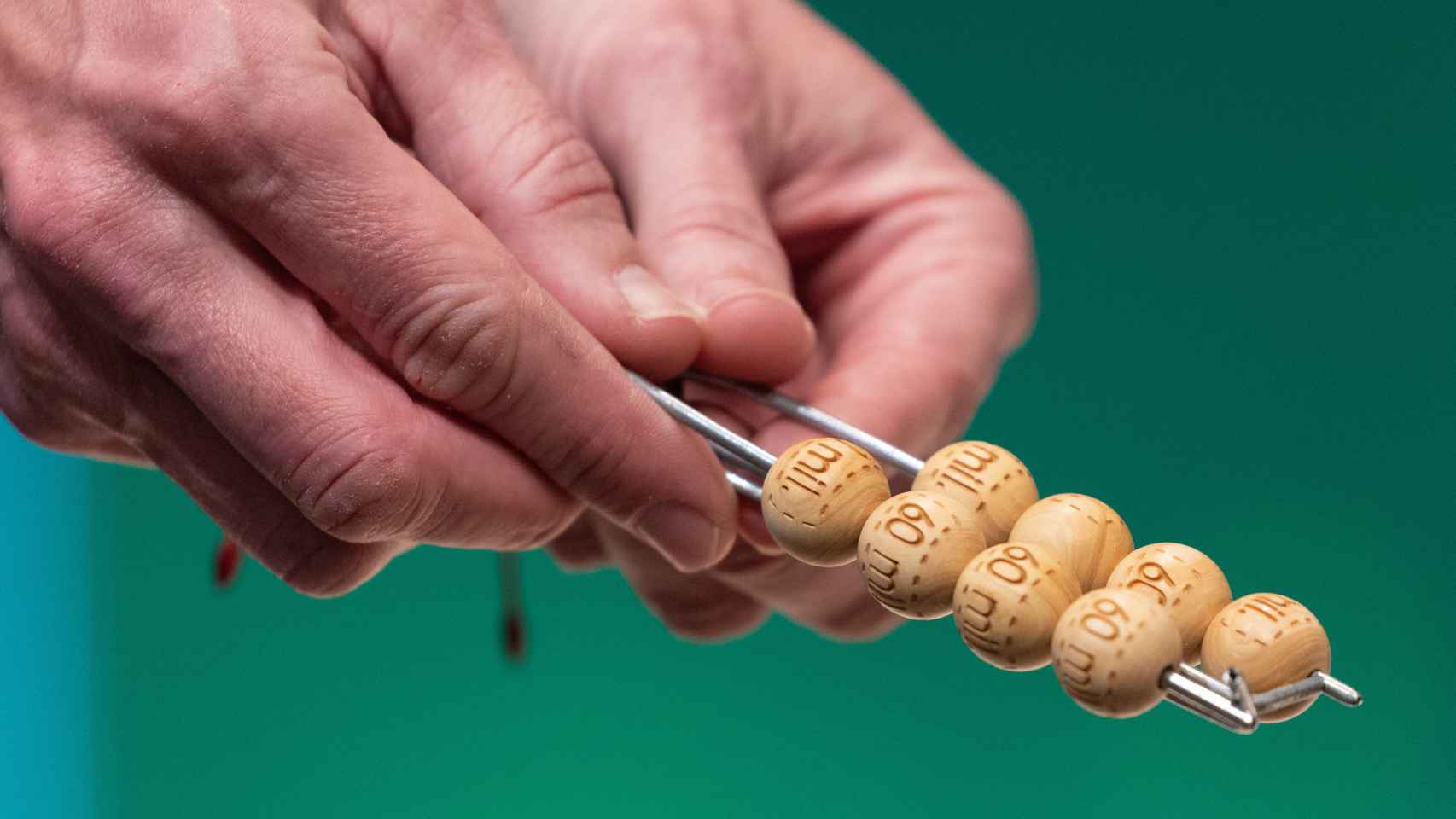 Un hombre manipula las bolas del sorteo de Lotería de Navidad