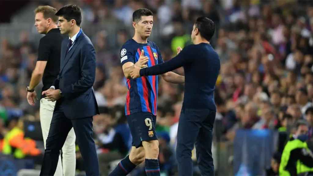 Xavi Hernández y Robert Lewandowski, saludándose en un partido