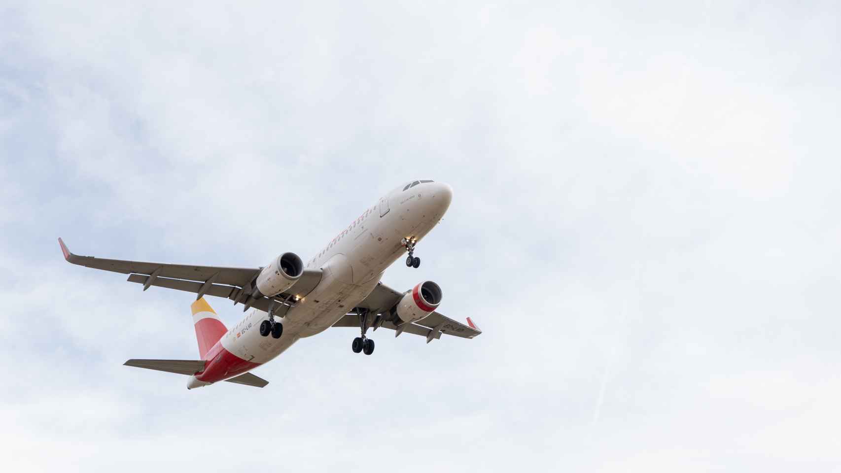 Un avión de Iberia sobrevuela el aeropuerto de El Prat