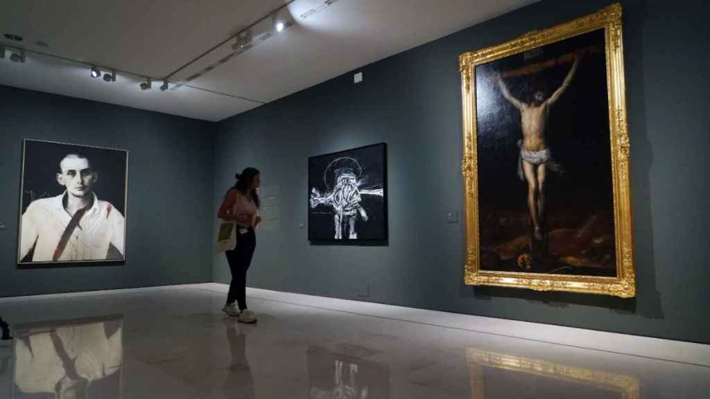 Una joven observa el diálogo planteado entre las crucifixiones de Antonio Saura (1959) y Antonio Pereda (1660).