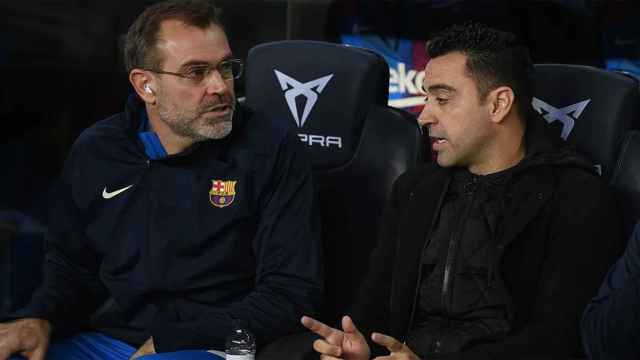 Xavi y Óscar Hernández, sentados en el banquillo del FC Barcelona