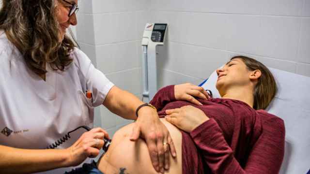 Una Matrona realiza la auscultación del latido fetal a una mujer embarazada