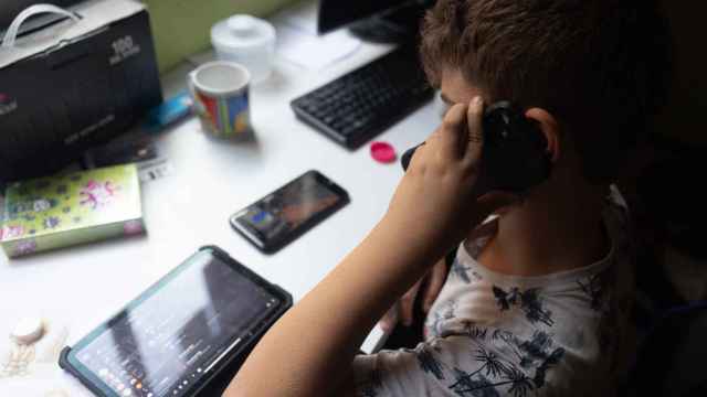 Un niño usa el teléfono móvil y una tablet, a 18 de octubre de 2023, en Madrid