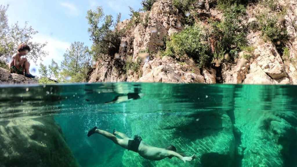 Una persona nada en una piscina natural del Forat del Buli