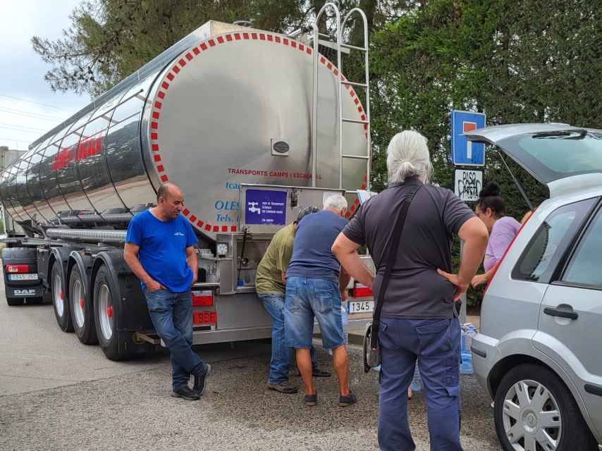 Vecinos de Vallirana llenando sus garrafas de un camión cisterna