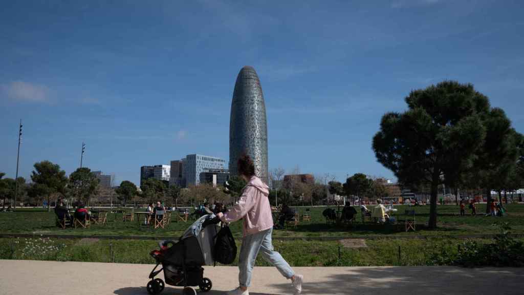 Una joven pasea con un carrito de bebé