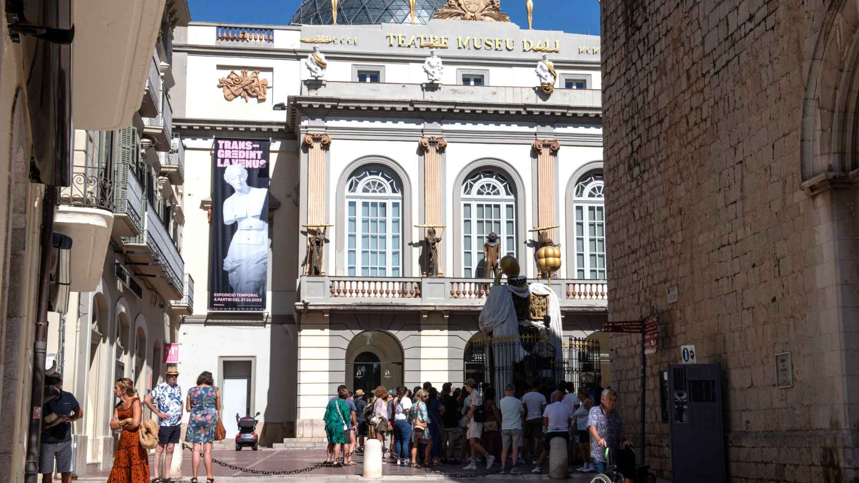 Varias personas hacen cola frente a una de las fachadas del Teatro-Museo Dalí