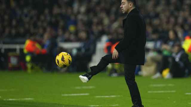 Xavi Hernández, pasando el balón desde el banquillo del Barça