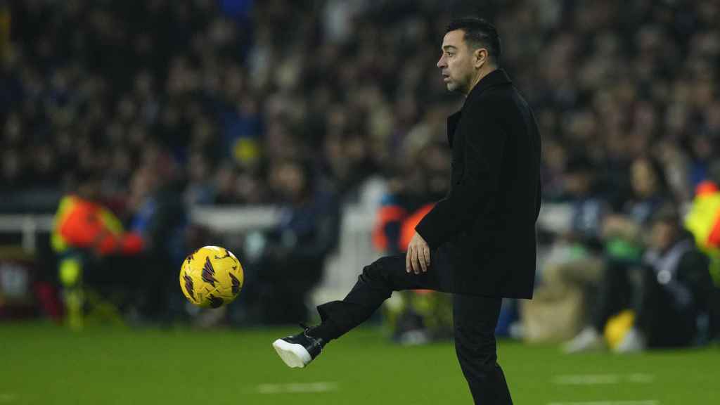Xavi Hernández, pasando el balón desde el banquillo del Barça