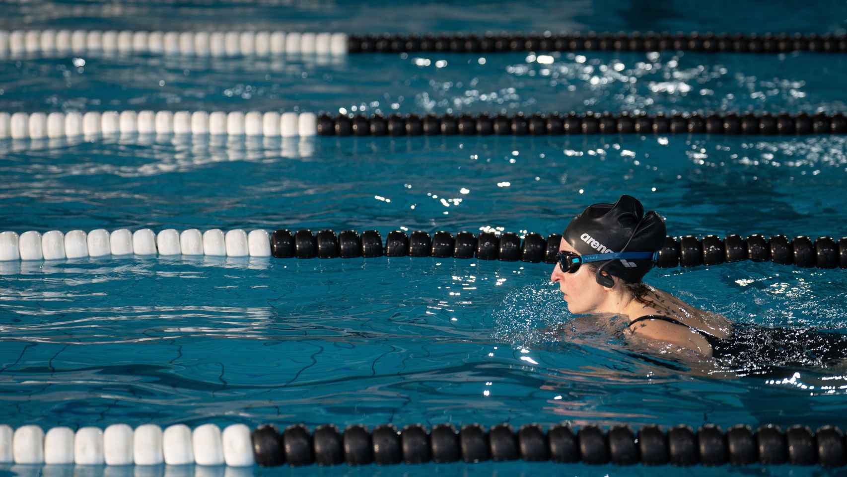 Una persona nada en una piscina de un centro deportivo