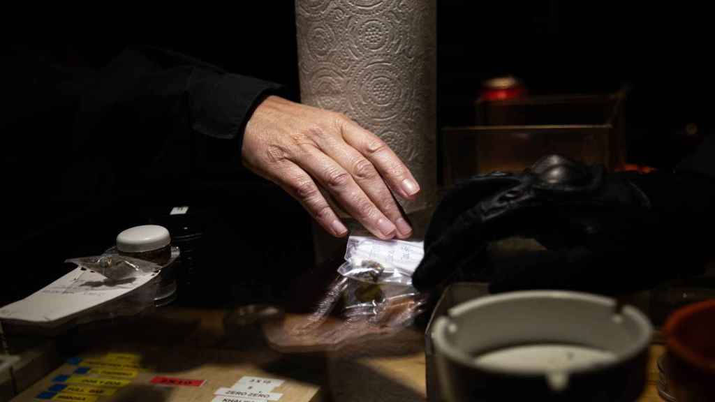 Un socio de un club cannábico entrega hachís a un agente de Mossos, en una imagen de archivo