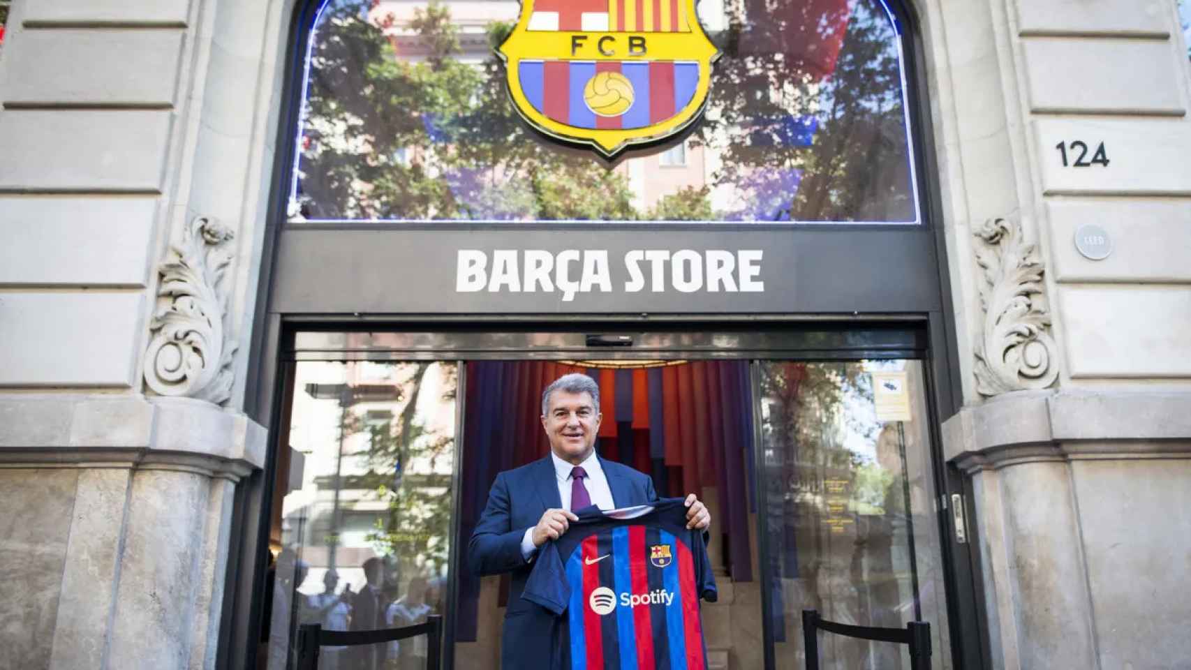 Laporta sujeta la camiseta azulgrana frente a una Barça Store