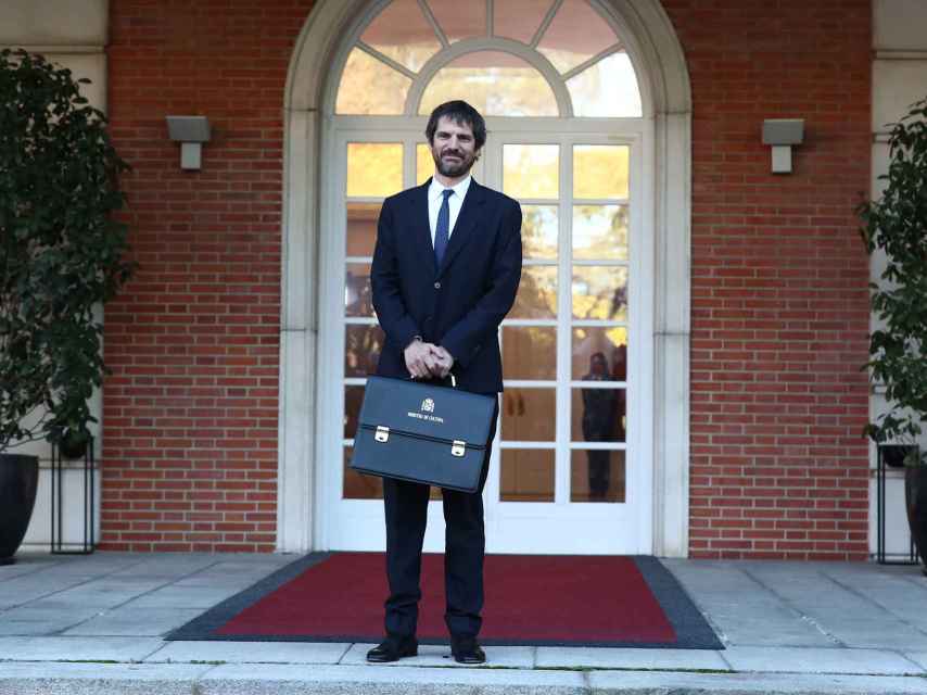 El ministro de Cultura, Ernest Urtasun, posa con su cartera en la escalinata de La Moncloa.