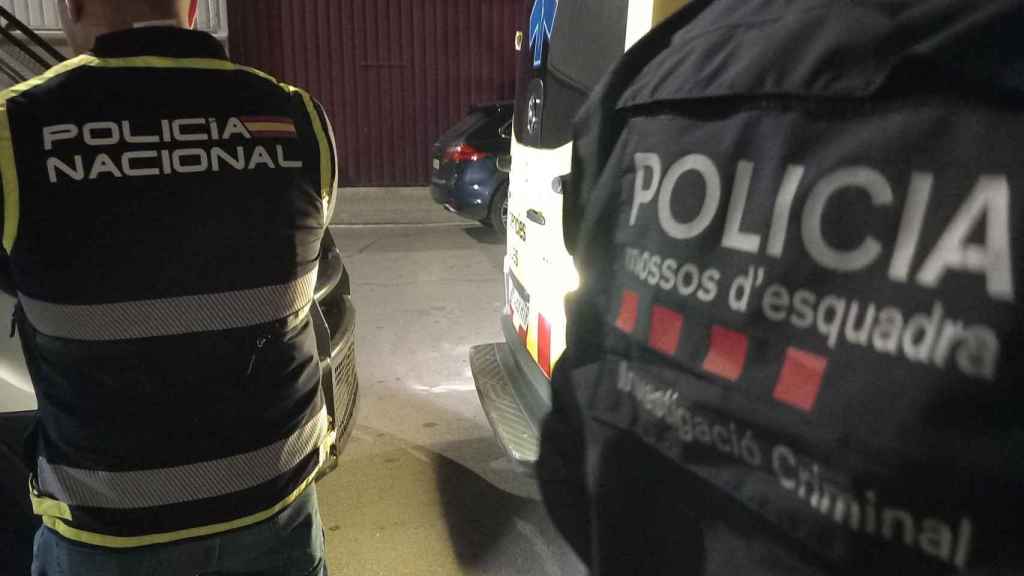 Un agente de los Mossos d'Esquadra con un efectivo del CNP