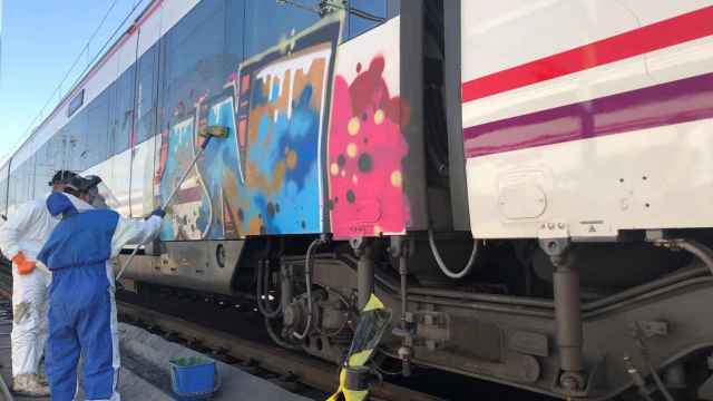Operarios de Renfe trabajan para borrar los grafitis de los trenes de Rodalies / EP