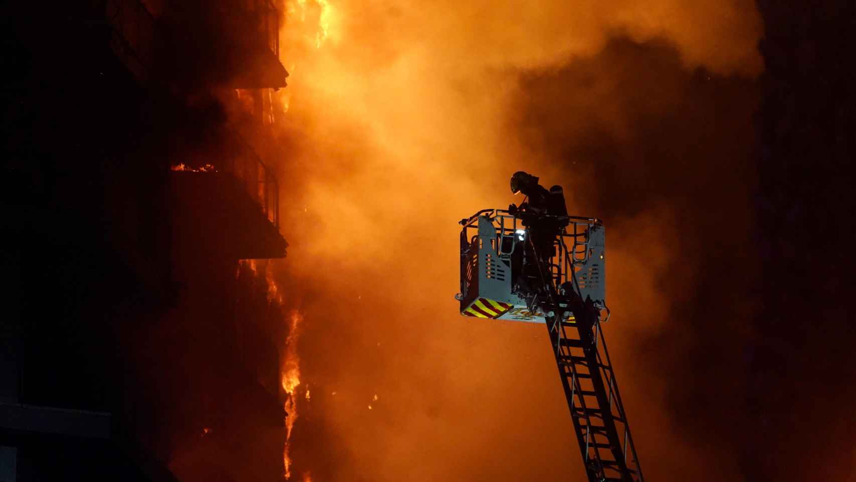 Un bombero trata de apagar el edificio en llamas