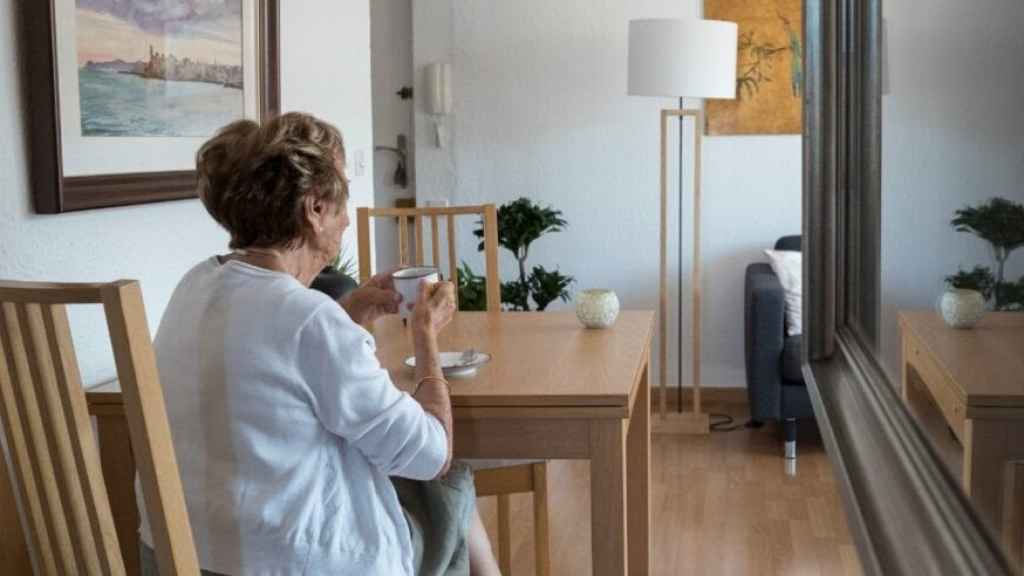 Una mujer mayor tomando café