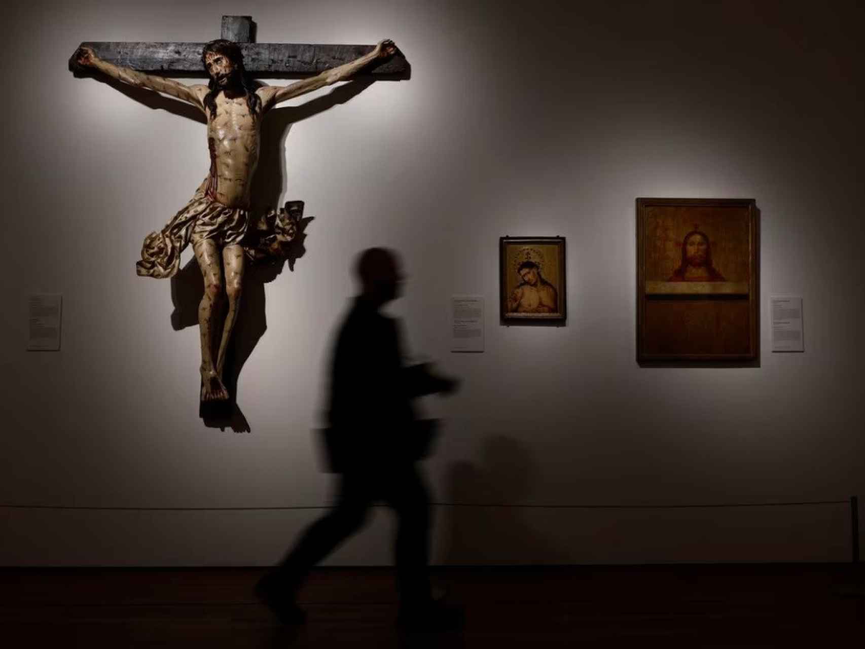Una persona pasa por delante del ‘Cristo crucificado’ de Gil Siloé (1488-90), una de las obras de la exposición ‘El espejo perdido’.