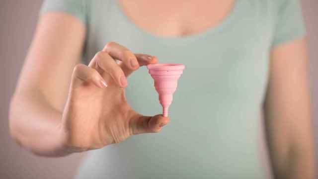 Una mujer muestra una copa menstrual
