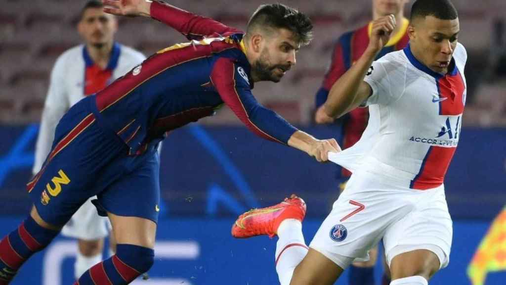 Gerard Piqué intentando frenar a Kylian Mbappé en 2021