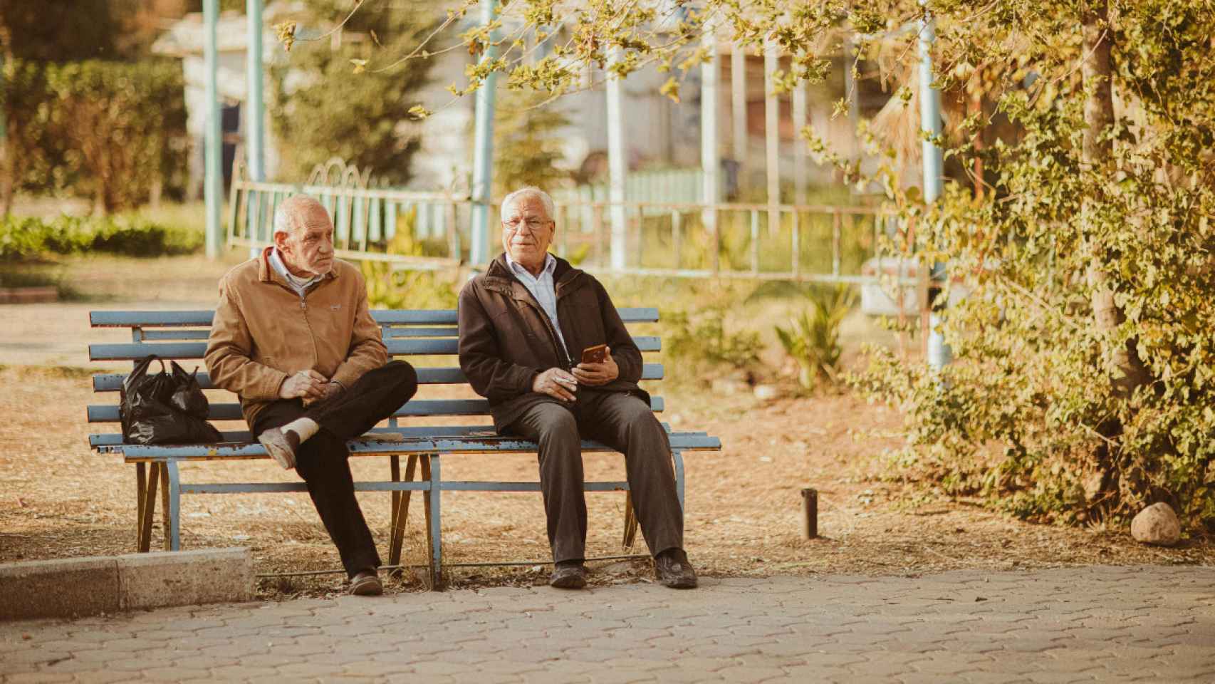 Imagen de archivo de dos personas mayores hablando en un banco