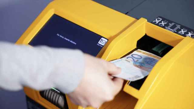 Una consumidora utilizando una máquina de dinero en efectivo