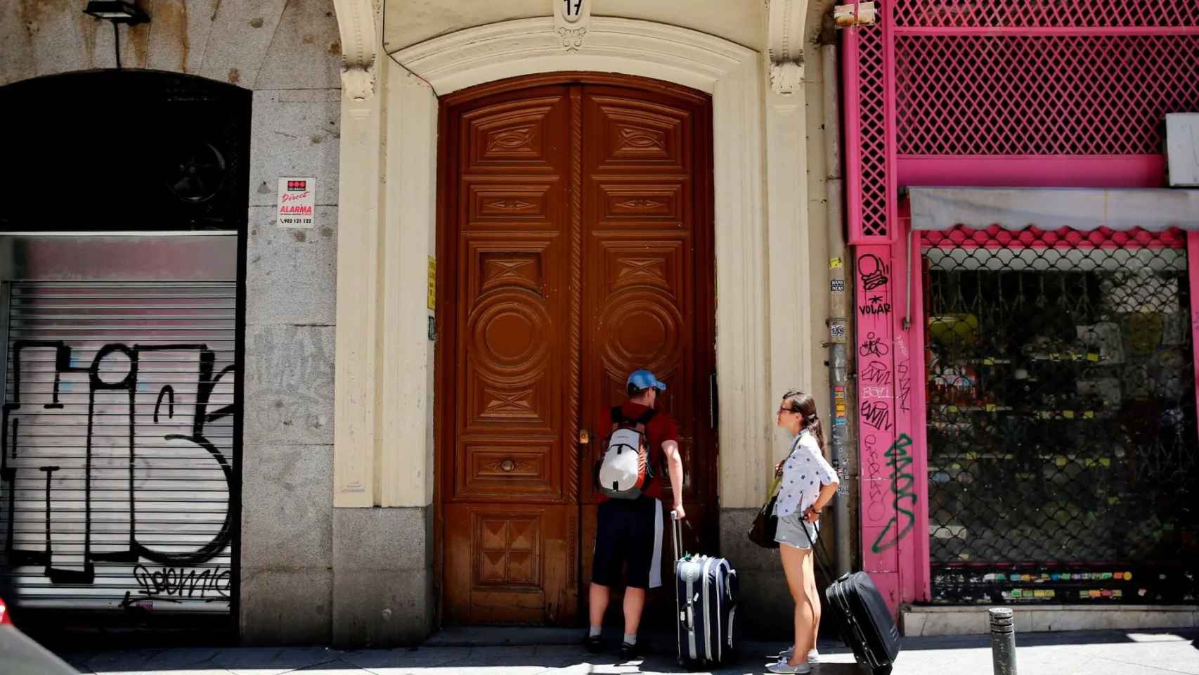 Dos turistas, ante un bloque vacacional en Barcelona