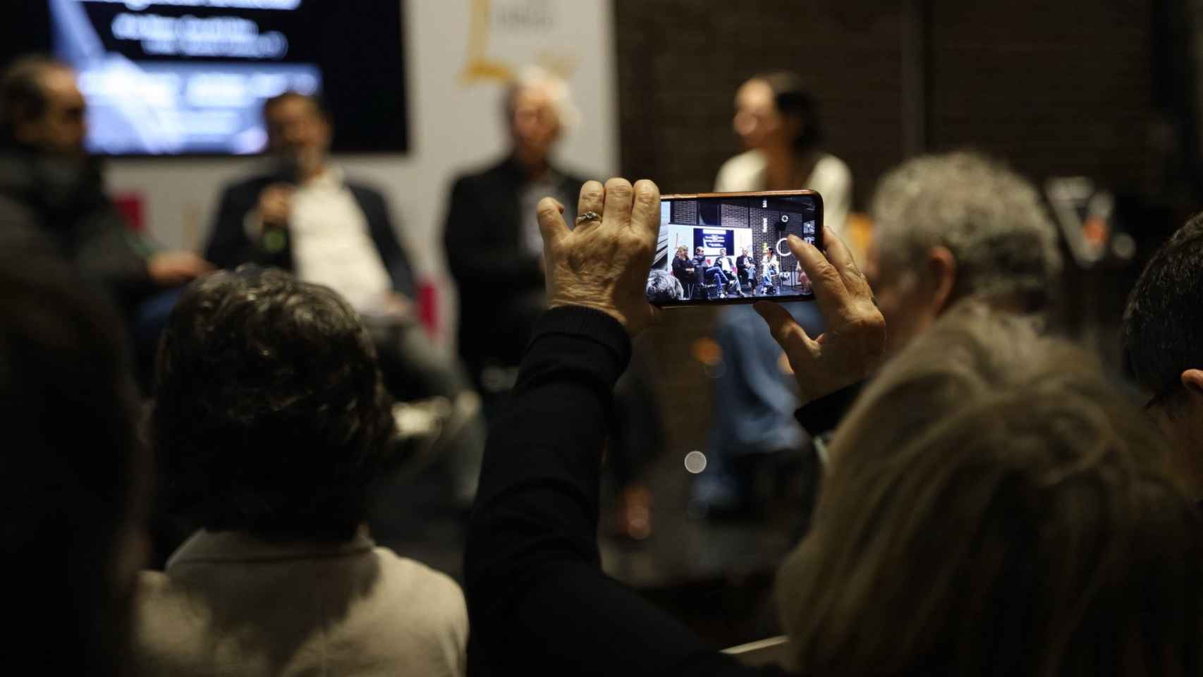 Asistentes toman imágenes del acto, en la Casa del Libro, con 'Letra Global'