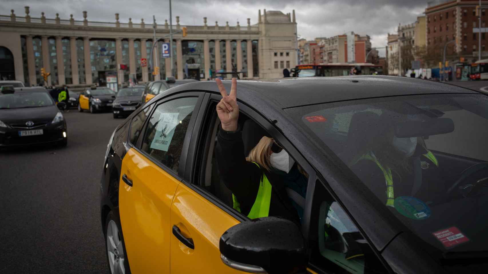 Un taxista de Barcelona saca la mano por la ventanilla haciendo el signo de la victoria con los dedos