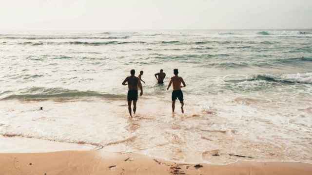 Imagen de archivo de un grupo de amigos bañándose en la playa