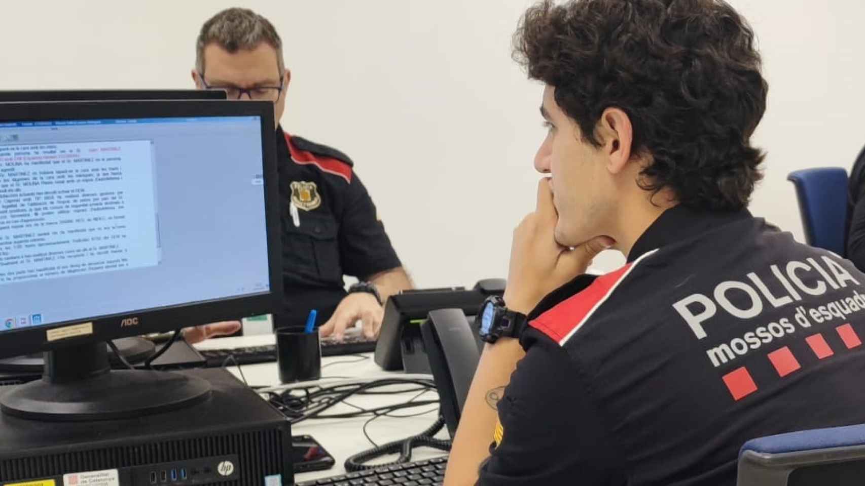 Varios mossos trabajan con el ordenador