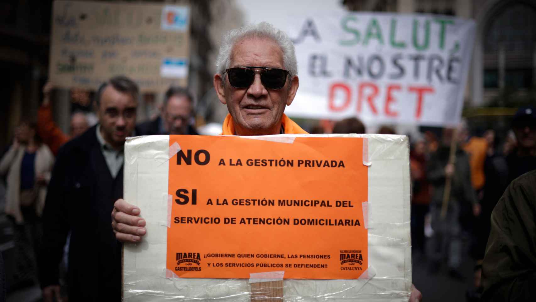 Un hombre sujeta un cartel durante la manifestación en defensa de la sanidad pública en Barcelona