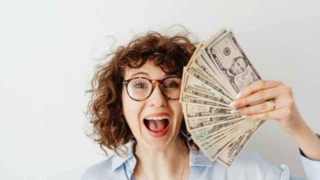 Una mujer feliz porque tiene dinero | PEXELS
